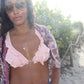 woman on beach in pink bikini and matching paisley jacket in sunglasses wearing the palm tree pendant from the wandering jewel
