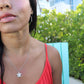 woman in orange top wearing the 7 diamond turtle necklace from the wandering jewel