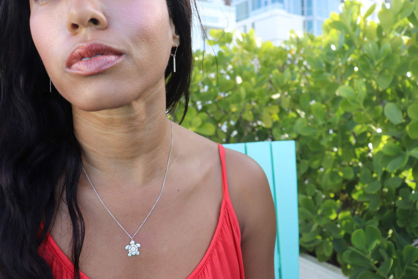 woman in orange top wearing the 7 diamond turtle necklace from the wandering jewel
