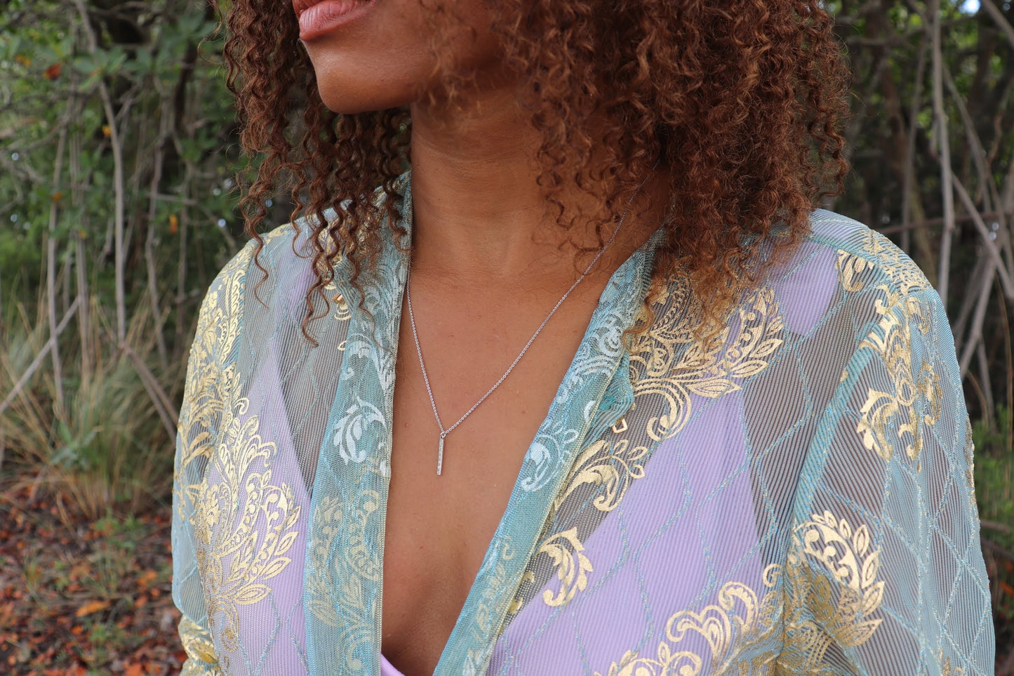 woman in aqua gown wearing the 7 diamond pillar necklace from the wandering jewel
