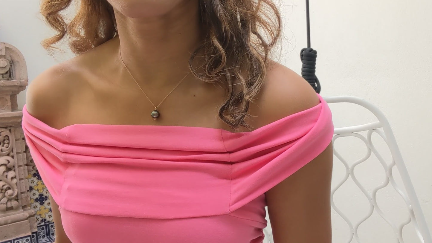 black woman in hot pink bodycon dress wearing the black South sea pearll pendant necklace from the wandering jewel