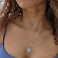 woman purple bikini with long brown curly hair wearing the 7 diamond star of david coin pendant by the wandering jewel