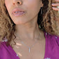 black woman with  purple dress wearing the wandering jewels 7 diamond  pillar earring and matching necklace