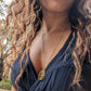 black woman with curly hair wearing the 7 diamond compass necklace from the wandering jewel