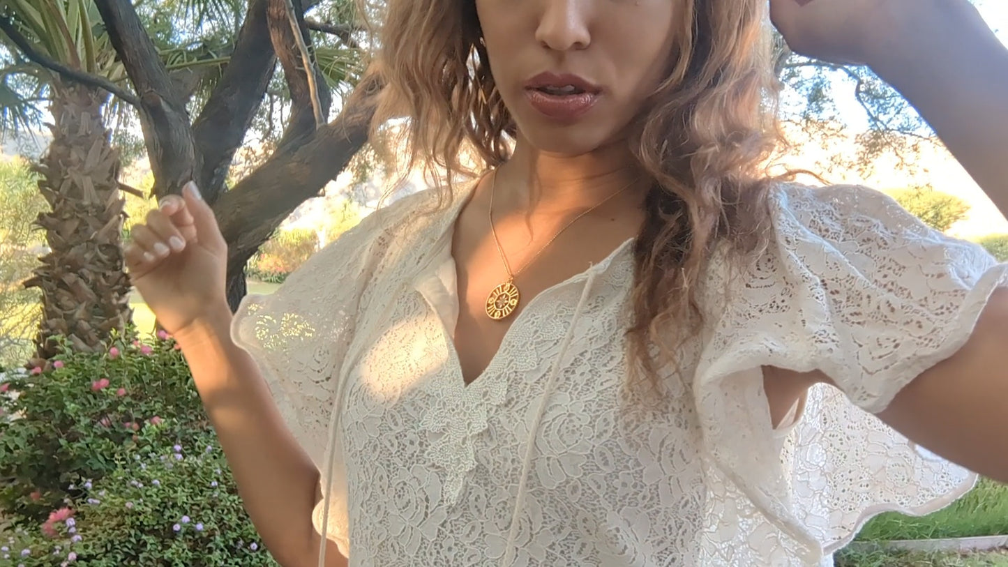 black woman in white dress in garden wearing the 7 diamond pendant necklace from the wandering jewel