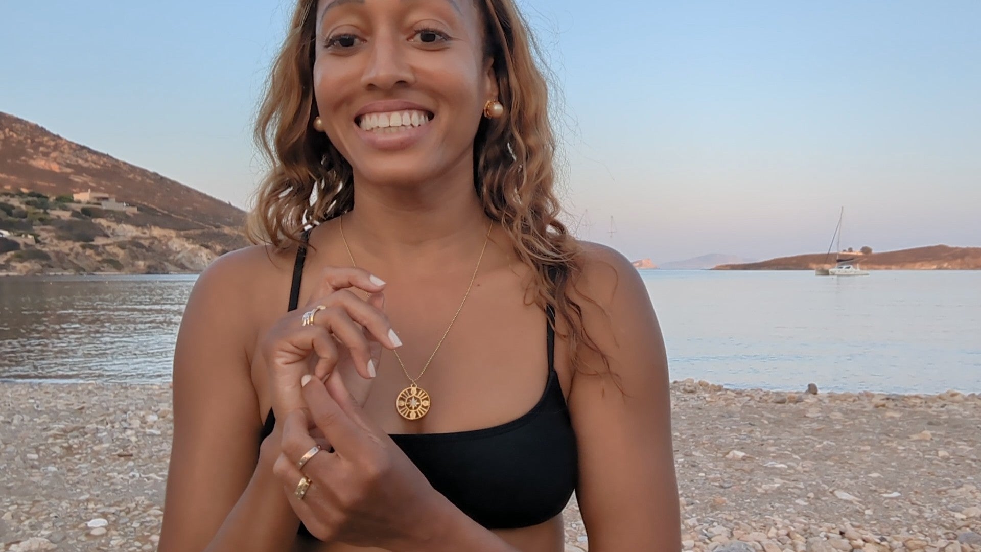 woman in black bikini on beach wearing the 7 diamond compass necklace from the wandering jewel