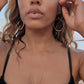 woman in black bikini on beach wearing Large gold hoop diamond earrings septagon shaped from the wandering jewel