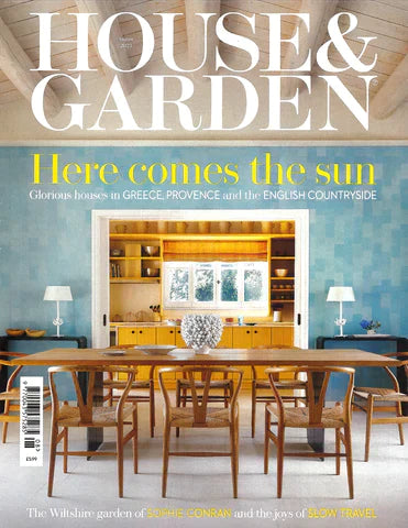 house and garden magazine cover featuring a minimalist brown table and chairs and also highlighting jewelry from the wandering jewel
