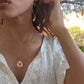 video of woman in white dress in a garden wearing the moon and Star cutout  coin necklace from the wandering jewel