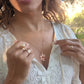video of smiling black woman in white dress in a garden wearing the Rose gold star of David pendant necklace coin from the wandering jewel