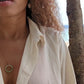 video of black woman in orange bikini and oversized white blouse on beach wearing the 18K Solid Rose Gold green jade ring on rose gold necklace from the wandering jewel