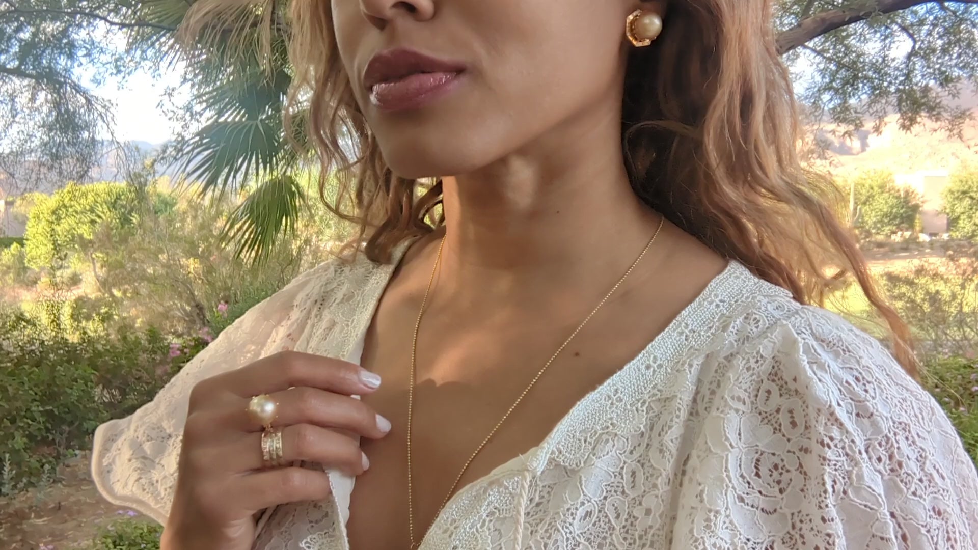 video of black woman in garden wearing white dress and smiling while wearing the Large oversized South sea pearl diamond ring from the wandering jewel