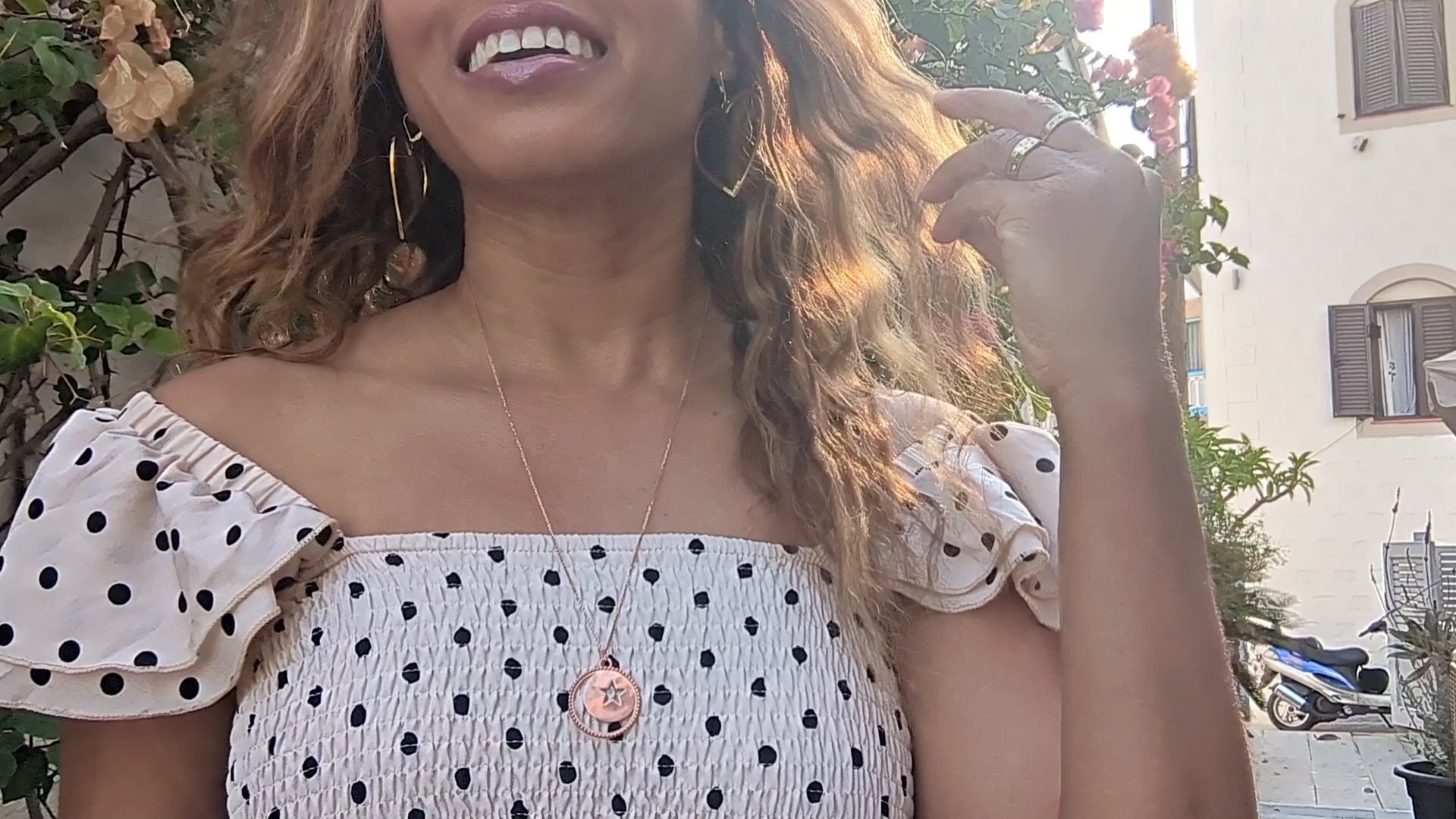 video of woman in a polka dot dress in European street wearing the moon and Star cutout coin necklace from the wandering jewel