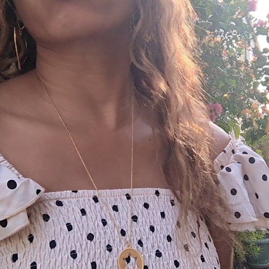 video of black woman wearing a polka dot dress on a European street and wearing the Rose gold star of David pendant necklace coin from the wandering jewel