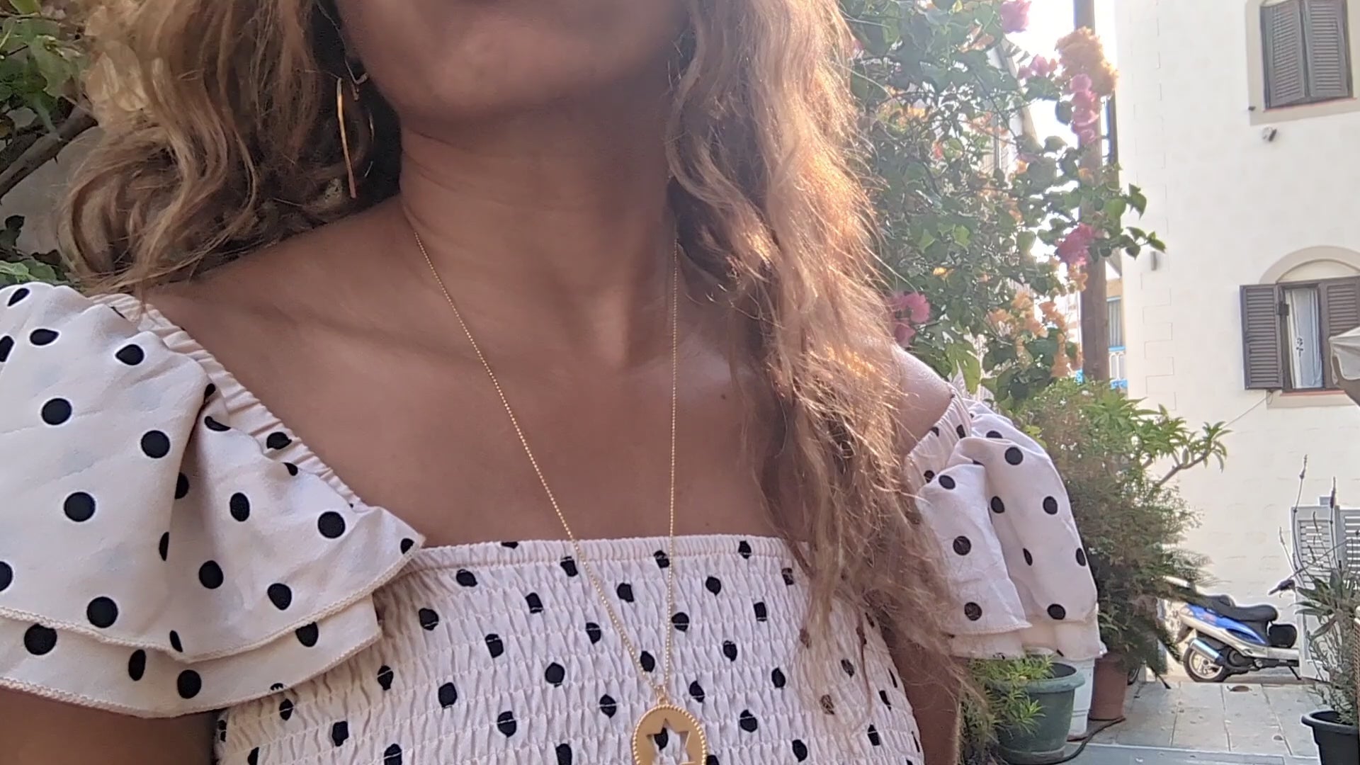 video of black woman wearing a polka dot dress on a European street and wearing the Rose gold star of David pendant necklace coin from the wandering jewel