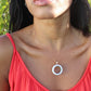 woman wearing orange top and wearing white jade ring necklace