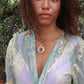 woman wearing green on forest wearing white jade ring necklace from the wandering jewel