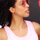  woman with sunglasses with a pink tank top wearing a diamond number  seven necklace