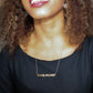 woman in black dress wearing gold goal digger necklace from the wandering jewel
