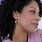 beautiful black woman with curly hair in pink dress woman  ice cream cone pearl pendant earrings