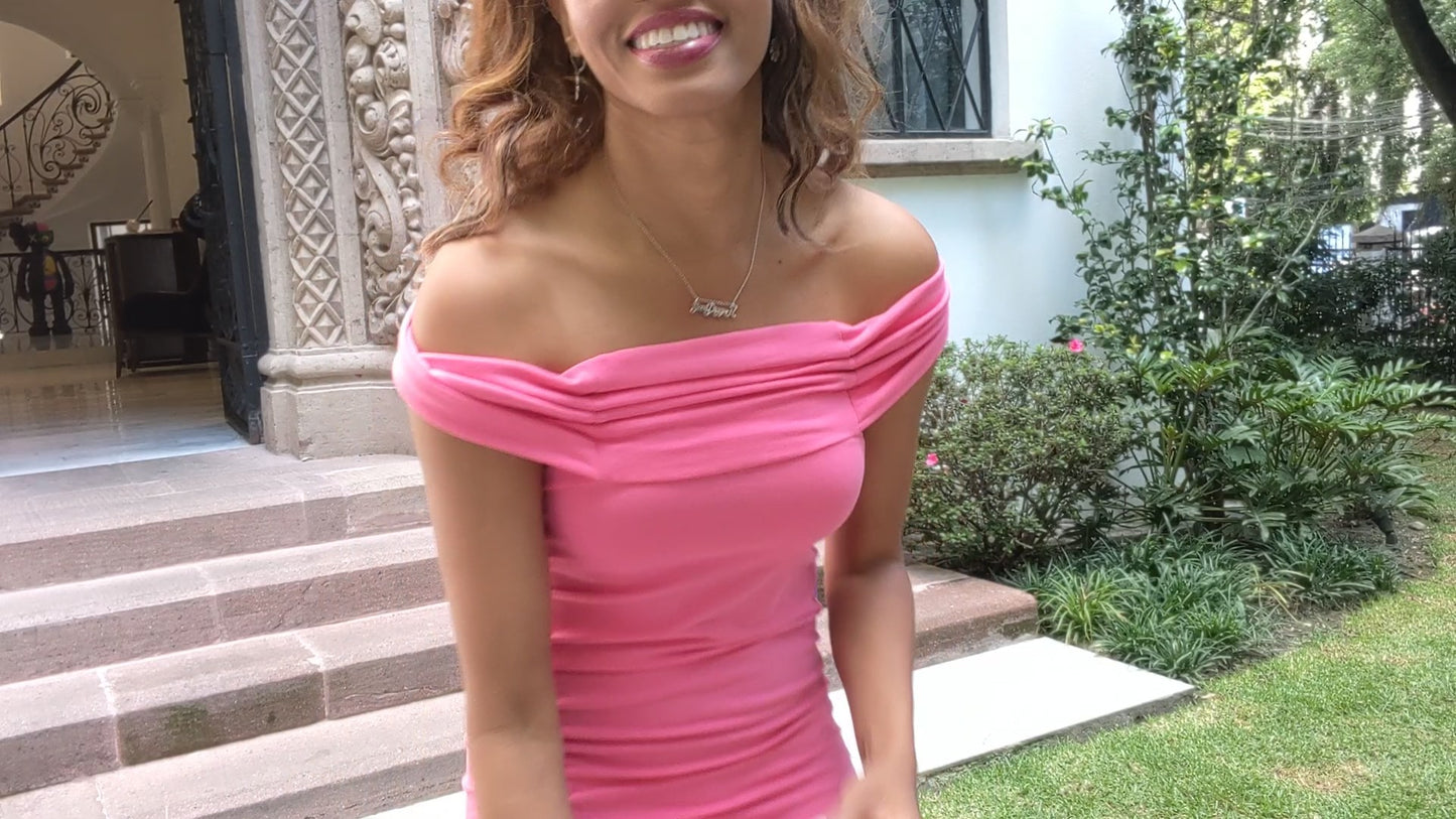 black woman in pink dress in front of mansion wearing goaldigger necklace