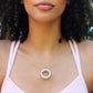 black woman with curly hair  in pink tank top wearing white jade necklace from the wandering jewel