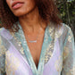 woman in forest wearing a blue and purple robe with a lavender tank top wearing mutha mother necklace