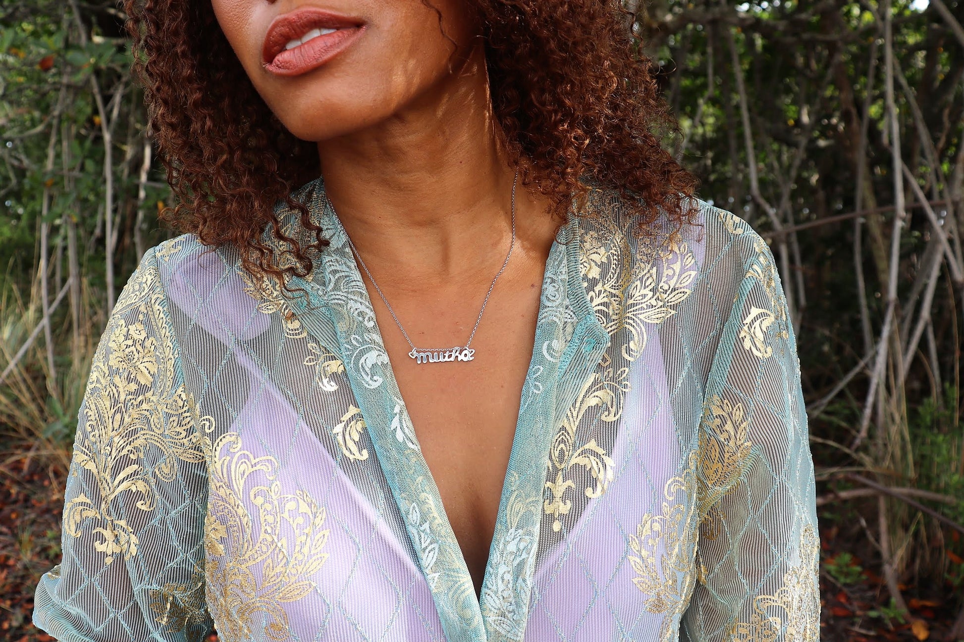 woman in forest wearing a blue and purple robe with a lavender tank top wearing mutha mother necklace from the wandering jewel