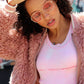 Rockstar in pink sunglasses and pink fur jacket  and pink tank top wearing black pearl necklace