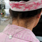 World Map charm on woman with pink jumpsuit and pink bandana