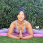 woman in workout leggings and tank top doing yoga splits and wearing two white jade ring necklaces from the wandering jewel