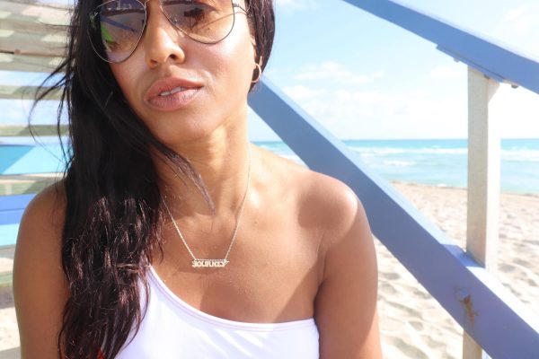 black woman on beach lifeguard stairs wearing the 7 diamond cocktail earrings from the wandering jewel