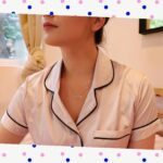 woman on bed in pink pajamas wearing mutha necklace