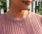 woman in pink shirt wearing mutha necklace