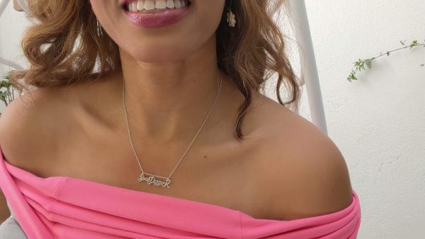 smiling black woman in pink dress wearing goaldigger necklace