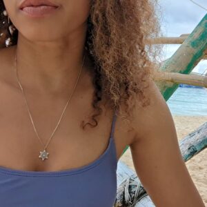woman in purple bikini on beach wearing the 7 diamond star of David pendant necklace from the wandering jewel