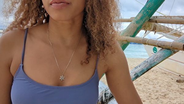 woman in purple bikini on beach wearing the 7 diamond star of David pendant necklace from the wandering jewel