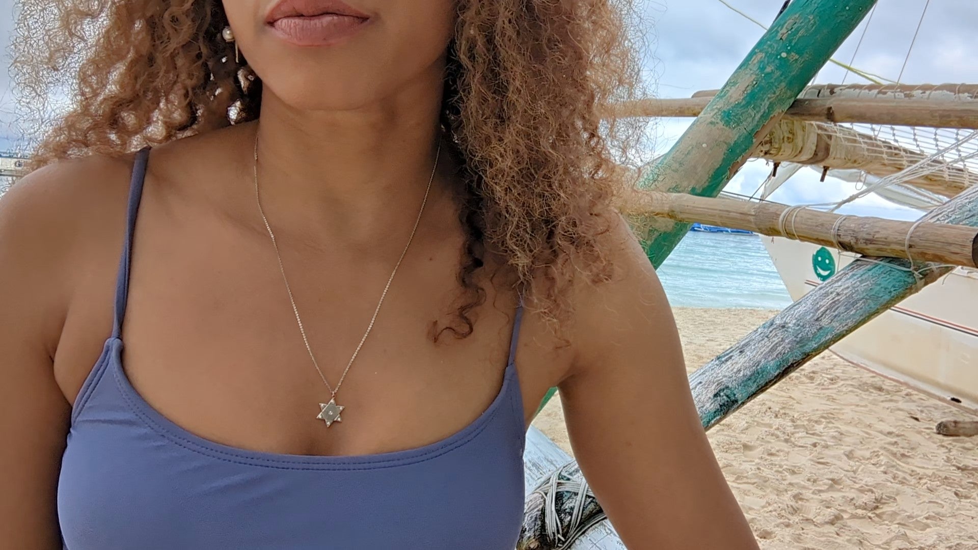 woman in purple bikini on beach wearing the 7 diamond star of David pendant necklace from the wandering jewel