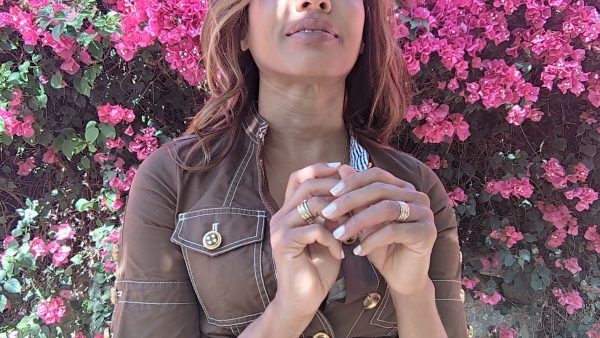 woman in brown dress standing in front of bright pink flowers and wearing 6 disengagement rings in 18K Solid white gold with 7 diamonds from the wandering jewel