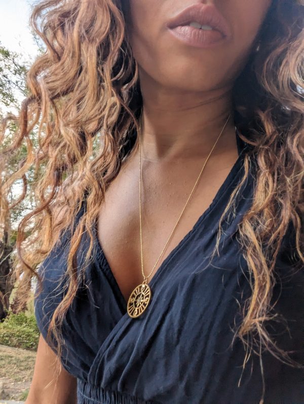 black woman with curly hair wearing the 7 diamond compass necklace from the wandering jewel