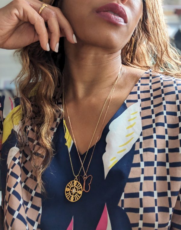 woman in colorful blouse wearing the 7 diamond cocktail butterfly pendant from The Wandering Jewel