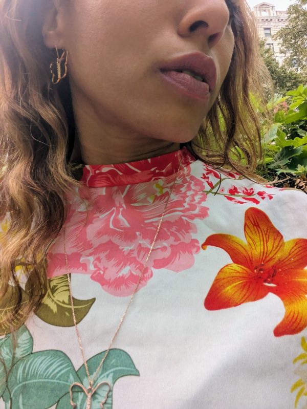 black woman in a multi color dress in garden wearing the 7 diamond butterfly earrings from The Wandering Jewel