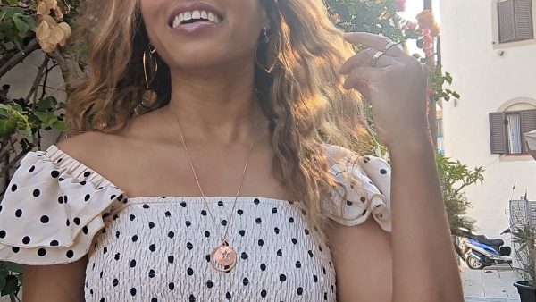 woman in polka dot dress in a street in Greece wearing a the moon and Star cutout coin necklace from the wandering jewel