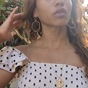 woman in polka dot dress on street in Europe wearing the 7 diamond Compass necklace from the wandering jewel