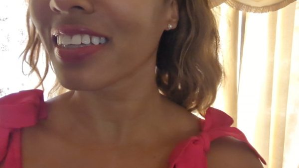 woman in pink dress in front of a window wearing the pearl and diamond Pentagon Stud earrings from the wandering jewel