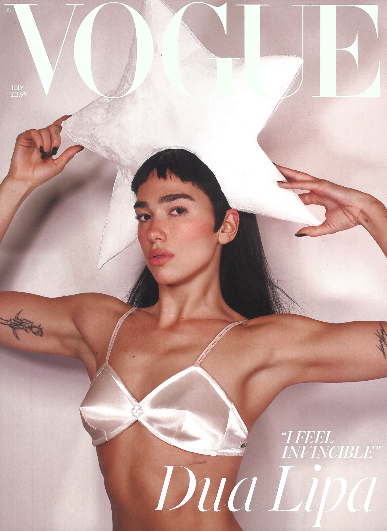 Vogue Cover of singer Dua lipa holding a large Star shaped Hat and wearing a white silk bra