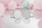 silver tiny heart patterned cufflinks from the wandering jewel on a mirrored table with pastel balloons in the background