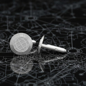 Cufflinks with the www world symbol on the face and shaped like a gold resting on a black marble surface that outlines a map